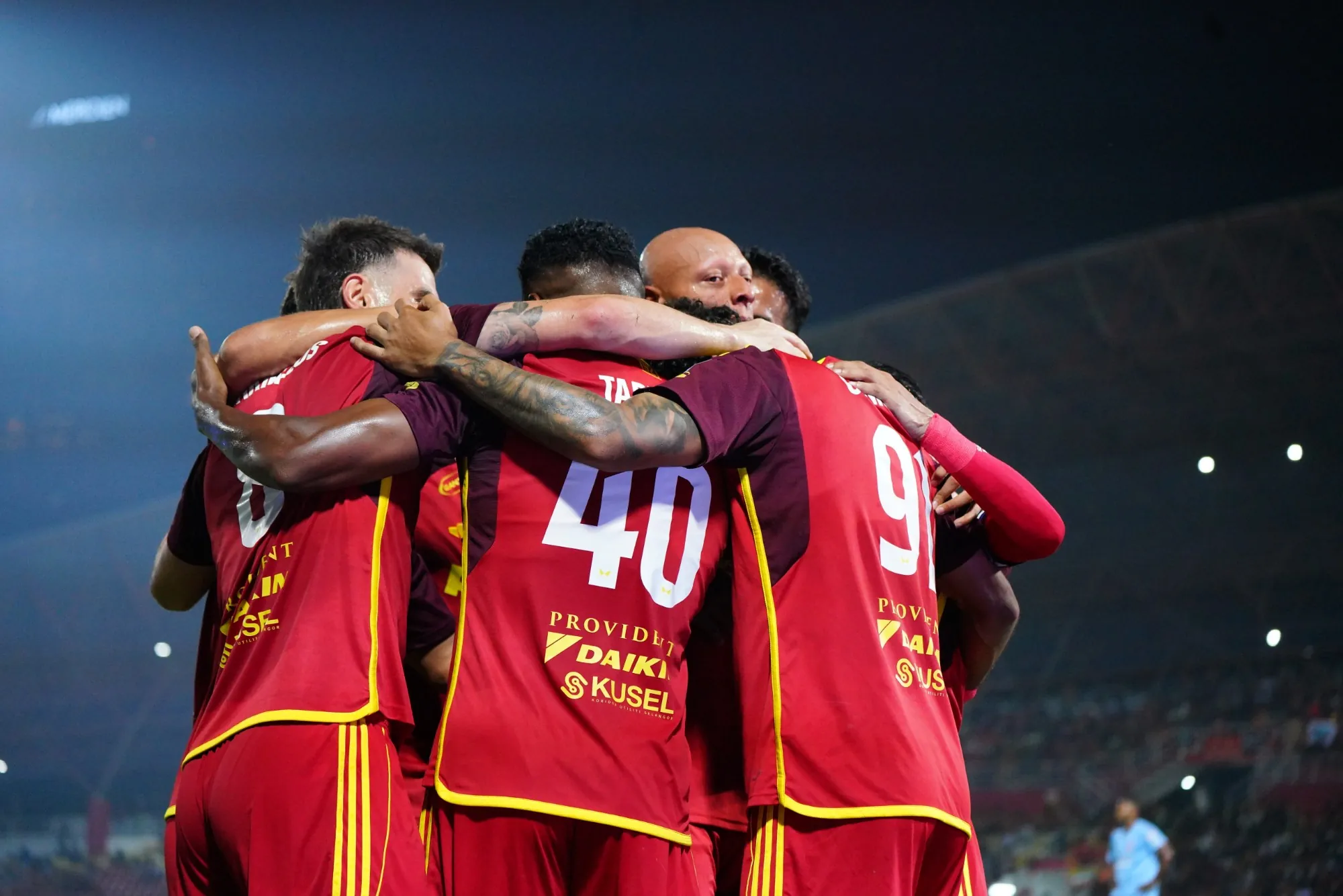 Selangor FC players celebrating a goal at night
